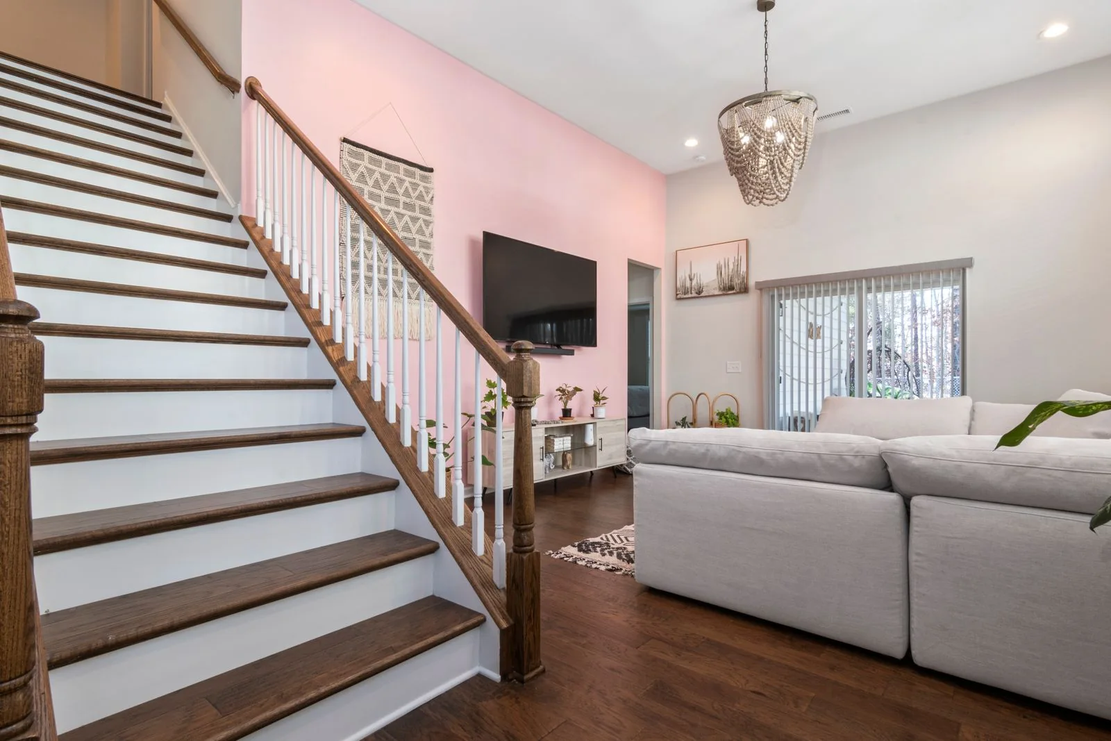 Living room sofa beside a wooden staircase, highlighting furniture and stair cleaning with INTETURE Cordless Vacuum